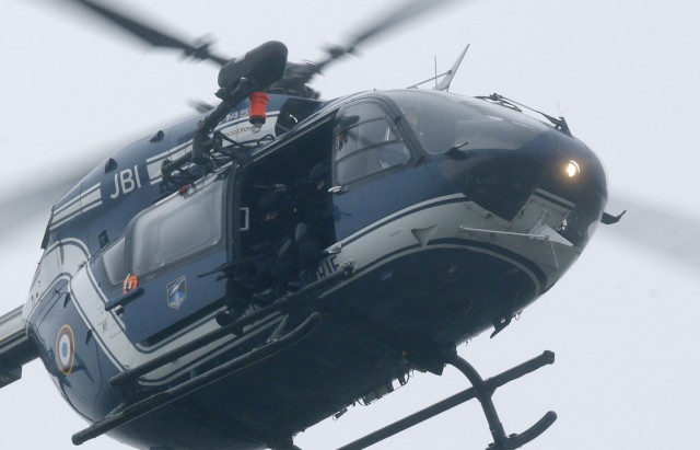 A helicopter with members of the French intervention gendarme forces hover above the scene of a hostage taking at an industrial zone in Dammartin-en-Goele, northeast of Paris