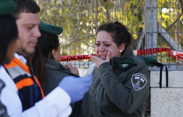 An Israeli police woman cries at the scene of an attack in Jerusalem