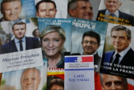 A photo illustration shows a French voter card in front of pictures of the candidates for the French presidential election