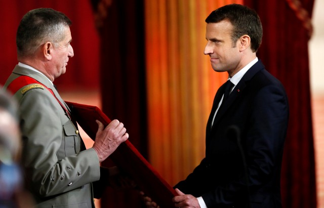 French President's Chief of Military Staff general Benoit Puga presents the Grand Collier in the Legion of Honor to French President Emmanuel Macron during the handover ceremony at the Elysee Palace in Paris